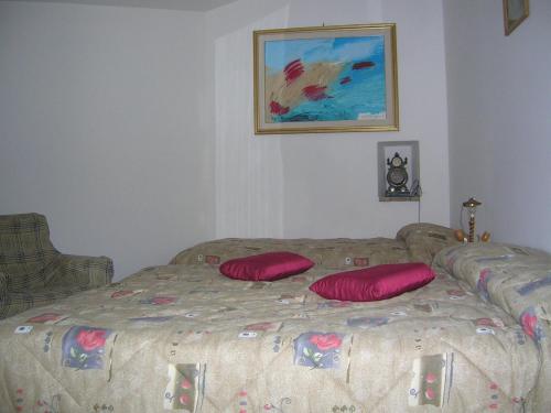 a bedroom with a bed with two red pillows on it at B&B La Terrazza Del Subasio in Assisi