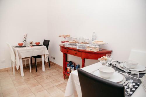 a kitchen with a table, chairs and a table cloth at Casa Marzia Affittacamere in Alghero