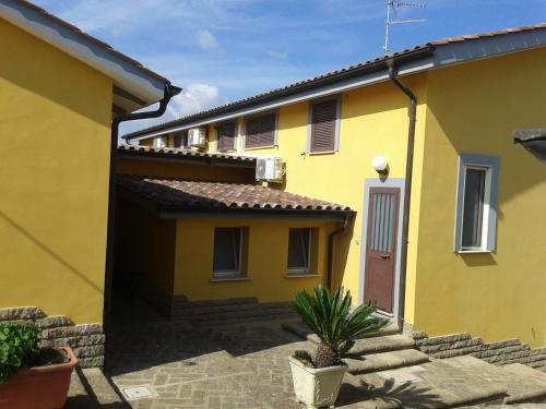 una casa amarilla con una escalera delante de ella en la Campagnola, en Cerveteri