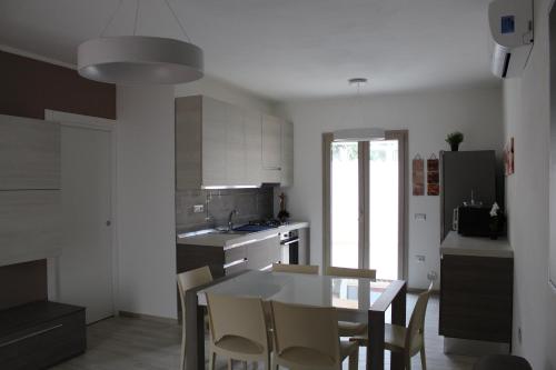 eine Küche mit einem Tisch und einigen Stühlen in der Unterkunft Casa Vacanze Calabro' in SantʼAntìoco