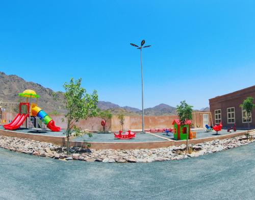 a playground with a water park with a slide at Alshahad farmhouse in Fujairah
