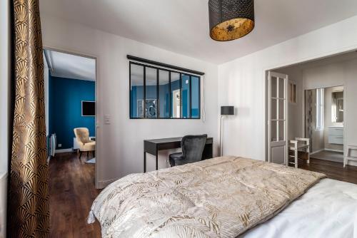 - une chambre avec un lit et un bureau dans l'établissement MM Suites Cathédrale, à Reims