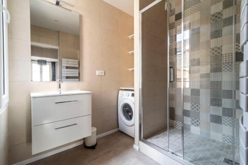 y baño con lavadora y ducha. en MM Suites Cathédrale, en Reims
