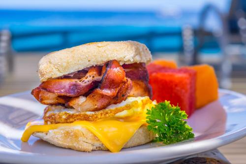 a breakfast sandwich with bacon and cheese on a plate at Lands End in West End