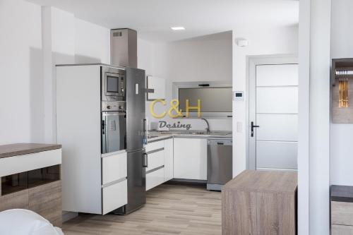 a kitchen with white cabinets and a refrigerator at Beyond Amadores C&H Suite in Amadores