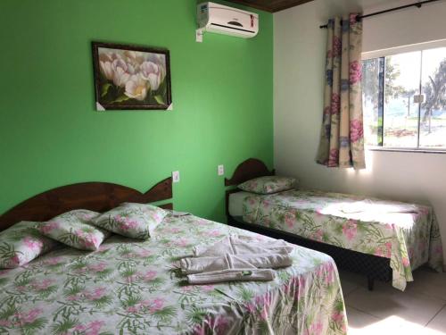 2 camas en una habitación con paredes verdes en Pousada Abraço Serrano, en Urubici