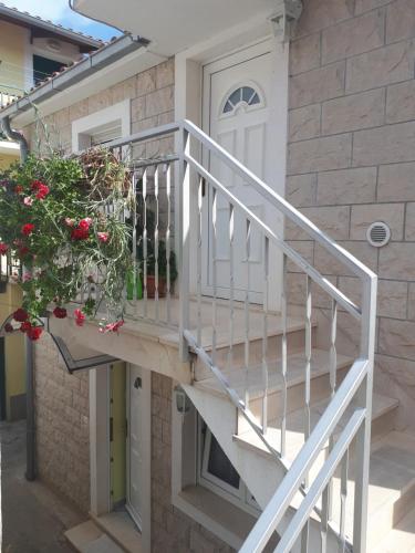 a white staircase next to a house with a plant at Apartments Duje in Split