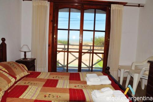 ビージャ・ヘセルにあるSaint Florentin Frente Al Marのベッドと大きな窓のある寝室