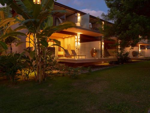a house with two chairs on a patio at night at Hotel Real Villa Bella in Ilhabela