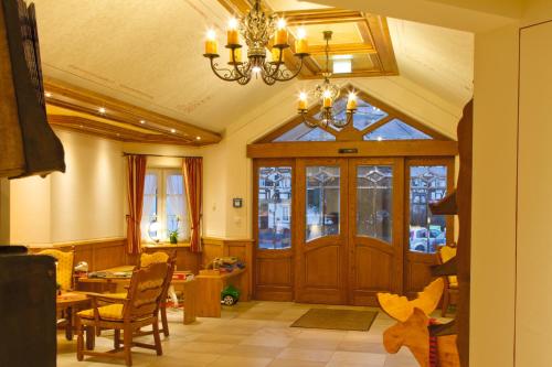 a living room with a wooden door and a table at Landhotel Voss im TalVital in Saalhausen