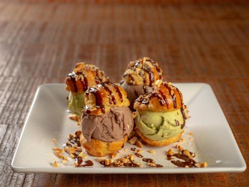 three scoops of ice cream on a white plate at Hotel Real Villa Bella in Ilhabela