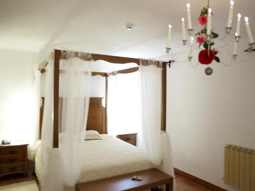 - une chambre avec un lit à baldaquin et un lustre dans l'établissement Dom Dinis Marvão, à Marvão