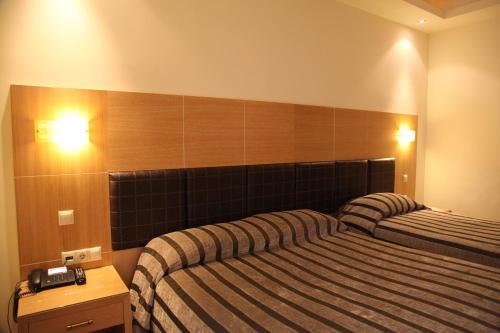 a hotel room with two beds in a room at Pantelidis Hotel & Spa in Ptolemaida