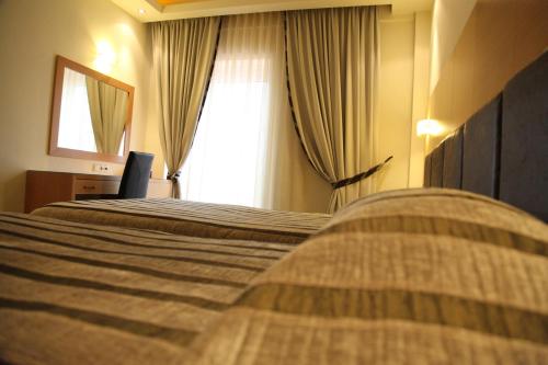 a hotel room with two beds and a window at Pantelidis Hotel & Spa in Ptolemaida