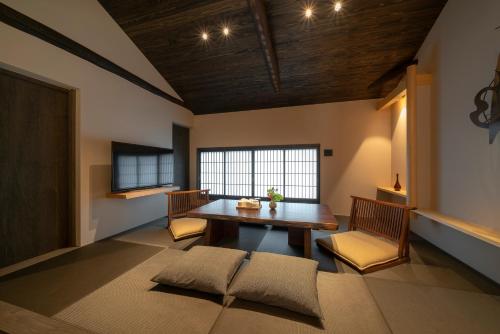 ein Esszimmer mit einem Holztisch und Stühlen in der Unterkunft Hinaya Gojo in Kyoto