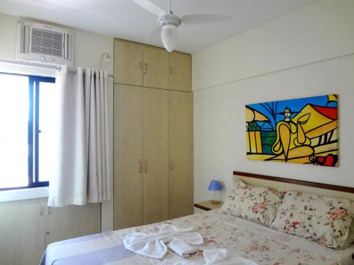 1 dormitorio con 1 cama y una pintura en la pared en Apartamento Ametista 2 + Bykes, en Maceió