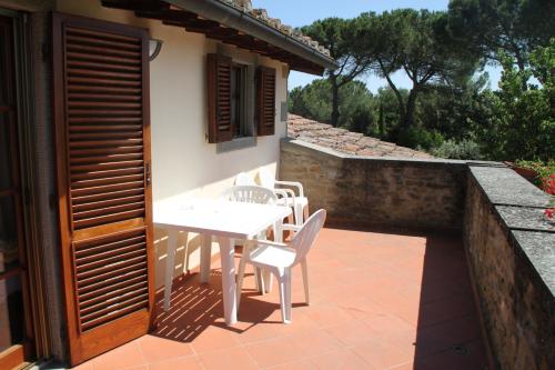 a white table and chairs on a patio at Ortali Country House in Quarata