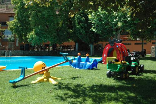 a group of toys in the grass near a pool at Hotel Rio Piedra in Nuévalos