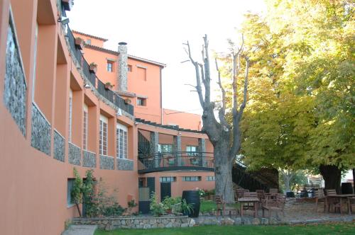 a building with a tree in front of it at Hotel Rio Piedra in Nuévalos