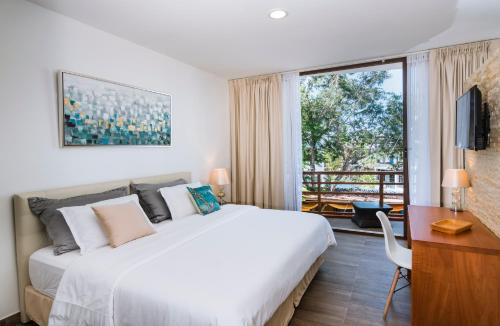 a bedroom with a bed and a desk and a window at Hotel La Isla in Puerto Ayora