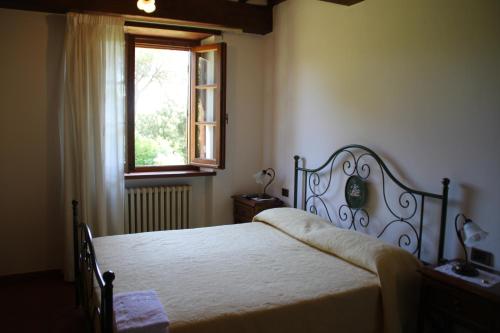 a bedroom with a large bed and a window at Ortali Country House in Quarata