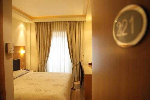 a hotel room with a bed and a clock on the wall at Pantelidis Hotel & Spa in Ptolemaida