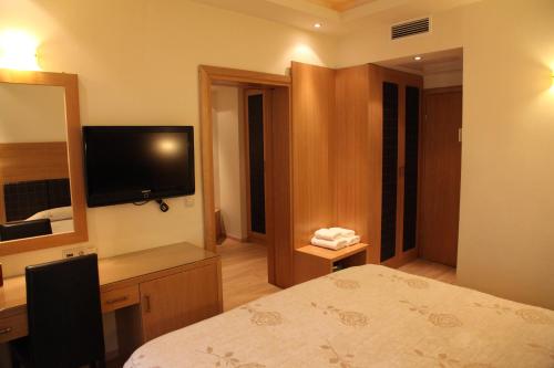 a hotel room with a bedroom with a bed and a mirror at Pantelidis Hotel & Spa in Ptolemaida