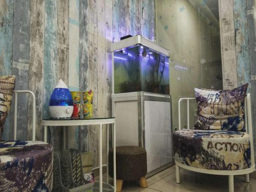 DreamCatchers Home في كُوانتان: غرفة بها حوض للأسماك وكرسي