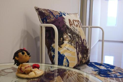 a glass table in front of a chair with a toy at DreamCatchers Home in Kuantan