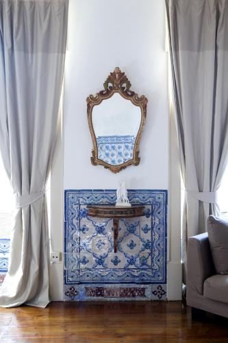 a room with a mirror and a table with a couch at Palacio Ramalhete in Lisbon