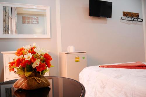 a room with a table with a vase of flowers at Kala Krang Nueng in Ko Samed