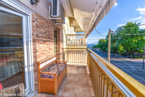 a balcony with a bench on a building at Menios Apartments and Studios in Nea Kalikratia