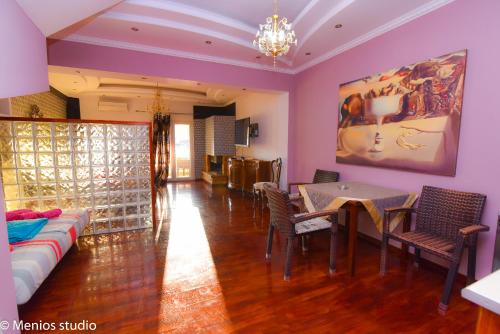 a living room with a couch and a table and chairs at Menios Apartments and Studios in Nea Kalikratia