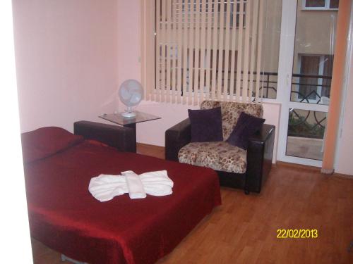 a living room with a bed and a chair at NELLY Guest House in Ravda