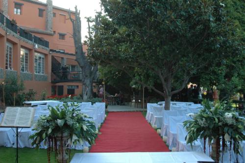 a red carpeted aisle with white tables and trees at Hotel Rio Piedra in Nuévalos