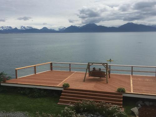 a wooden deck with a swing on the water at Homer Inn & Spa in Homer
