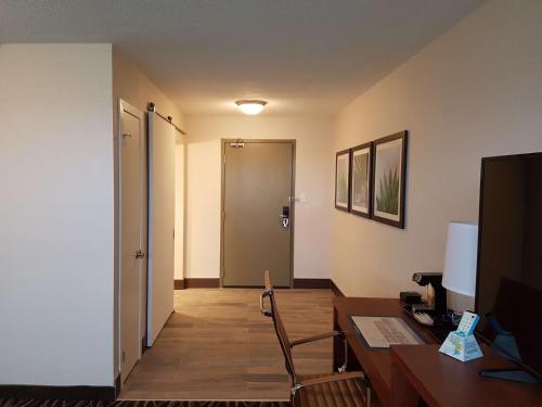 a room with a desk and a room with a door at Best Western Plus Durham Hotel & Conference Centre in Oshawa