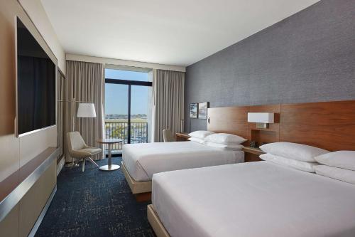 a hotel room with two beds and a television at Hyatt Regency John Wayne Airport Newport Beach in Newport Beach