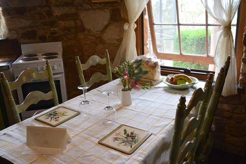 a kitchen with a table with a white table cloth at Trestrail Cottage Accommodation in Clare