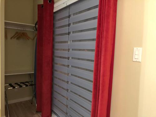 a closet with red curtains next to a wall at Petit Hôtel Amara in La Malbaie