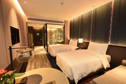 a hotel room with two beds and a couch at Wanda Realm Resort Nanning in Nanning