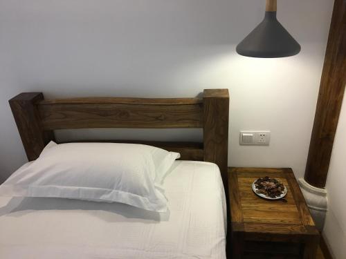 a bedroom with a bed and a table with a plate of food at Beijing Downtown Travelotel in Beijing