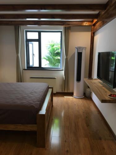 a bedroom with a bed and a flat screen tv at Beijing Downtown Travelotel in Beijing