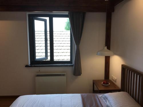 a bedroom with a bed and a window at Beijing Downtown Travelotel in Beijing