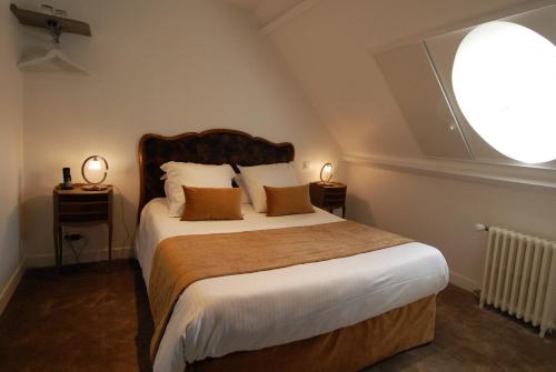a bedroom with a large bed with a large window at Domaine de Bayeux in Bayeux