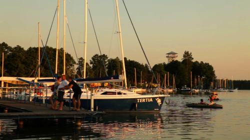 a group of people standing on a dock near a boat at Hotel Niedźwiadek in Wdzydze Kiszewskie