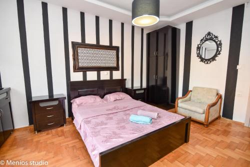 a bedroom with a bed and a chair at Menios Apartments and Studios in Nea Kalikratia