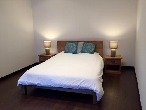um quarto com uma cama branca com duas mesas de cabeceira em Port de Nice em Nice