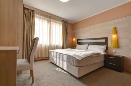 a bedroom with a bed and a desk and a chair at Teplice Plaza in Teplice