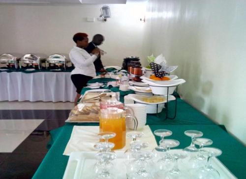 two people standing at a table with wine glasses at Lebanon Hotel in Kigali